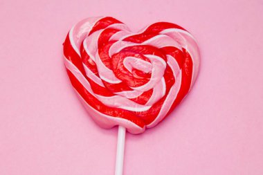 pembe bir arka plan üzerinde kalp lolipop