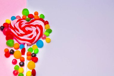 kalp lolipop ve şeker pembe ve gri arka plan üzerinde