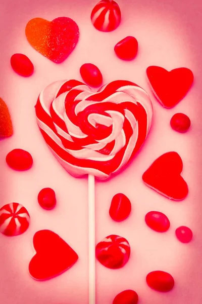 心脏棒棒糖和糖果在粉红色的背景 — 图库照片