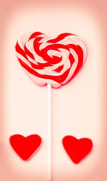 heart lollipop with heart candies on colorful background
