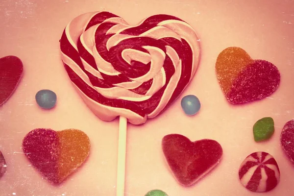 heart lollipop with heart candies on colorful background