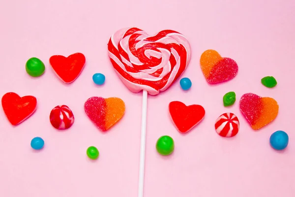 心脏棒棒糖与心脏糖果在五颜六色的背景 — 图库照片