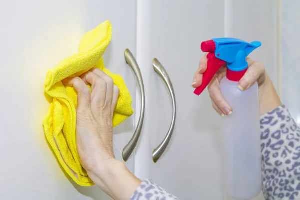 woman with spray and cloth cleaning tiles. Cleaning and disinfection concept