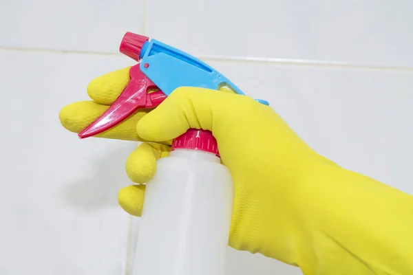 woman with spray and cloth cleaning tiles. Cleaning and disinfection concept