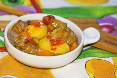 Seramik güveç etli güveç üzerinde renkli masa örtüsü