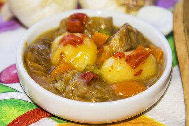 Seramik güveç etli güveç üzerinde renkli masa örtüsü