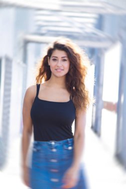 Genç kadın köprüde yürüyor.