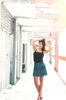 Genç kadın köprüde yürüyor.