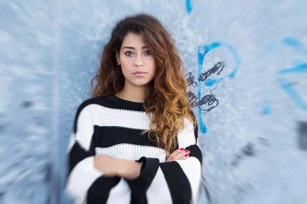 Young woman with sailor jersey leaning against the wall