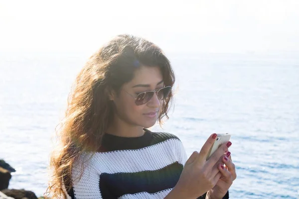 Girl talking on mobile phone at sea