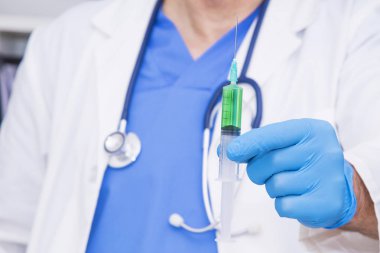 Elinde şırınga olan bir doktor.
