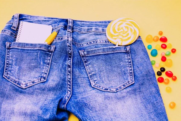 Lízátko Notebook Kapse Modré Kalhoty Žlutým Pozadím — Stock fotografie