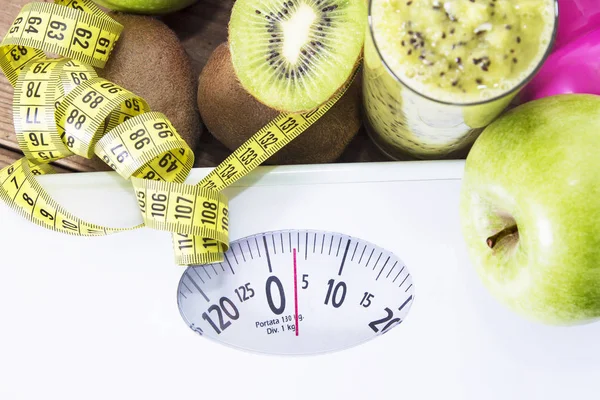 green juice, tape measure, scale and dumbbells. diet and slimming concept