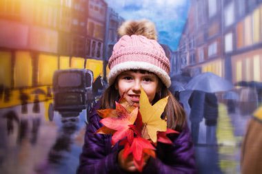 yağmurlu şehir arka plan ile sonbahar ile oynayan kız portresi bırakır