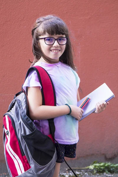 student with backpack and colored pencils going to school
