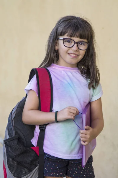 student with backpack and notebooks on yellow background, back to school