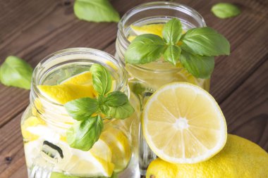 Ev yapımı ferahlatıcı limonata, limon dilimleri ve mason kavanozlarda buz.