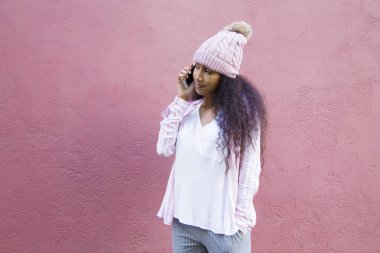 Yün şapkalı kız cep telefonuyla konuşuyor.