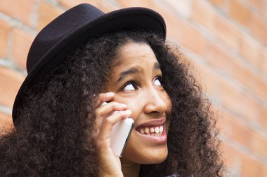 şapka ile afro kız onu cep telefonu konuşuyor