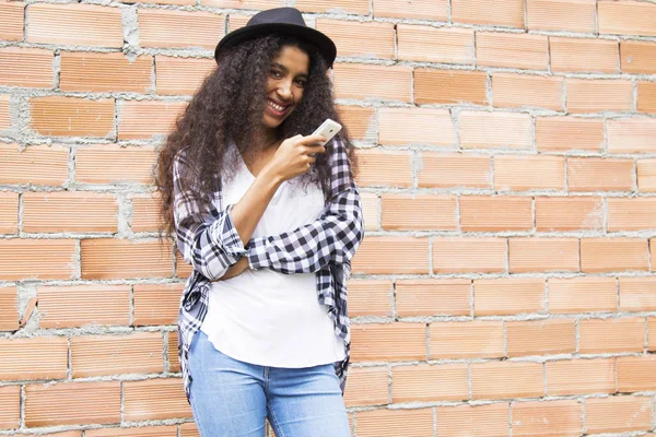 Mujer Afro Con Sombrero Con Teléfono Móvil Pared Ladrillo —  Fotos de Stock