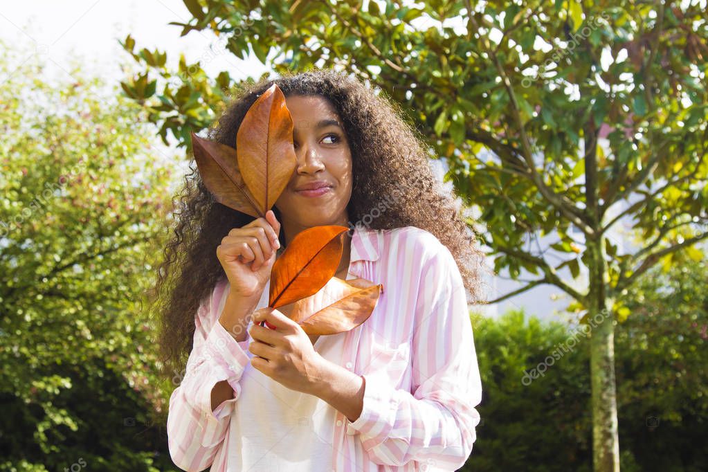 portrait of woman with leaves of tree in autumn