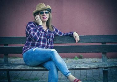 park bankında üst düzey kadın cep telefonu konuşuyor