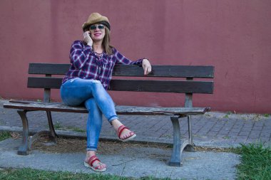 park bankında üst düzey kadın cep telefonu konuşuyor