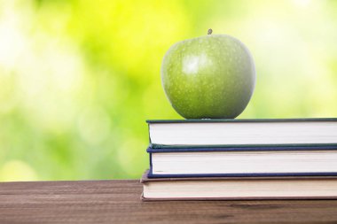 elma ve arka plan üzerinde yığılmış kitaplar ile okula geri kavramı