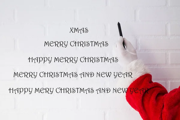 Weihnachtsmann Schreibt Weihnachts Und Neujahrsgrüße Auf Weiße Ziegelwand — Stockfoto