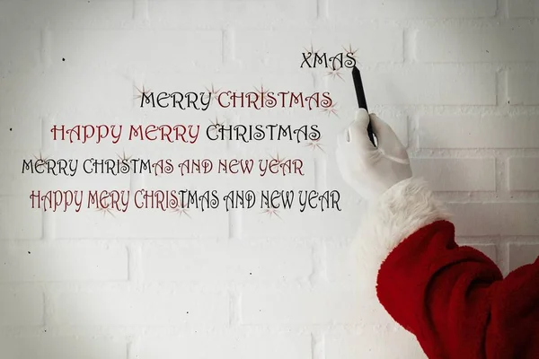 Weihnachtsmann Schreibt Weihnachts Und Neujahrsgrüße Auf Weiße Ziegelwand — Stockfoto