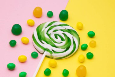 Sarı ve pembe arka planda lolipop ve şekerler