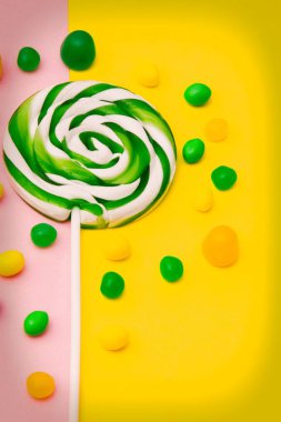 Sarı ve pembe arka planda lolipop ve şekerler
