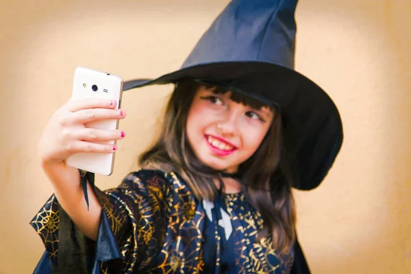 Menina Vestida Como Uma Bruxa Fazendo Uma Selfie Com Telefone — Fotografia de Stock