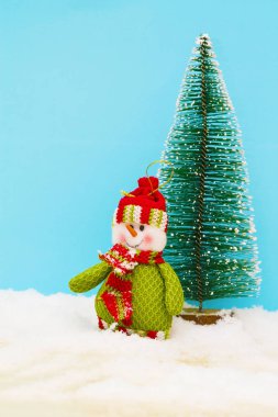 Mavi arka planda Noel ağacı ve kardan adam