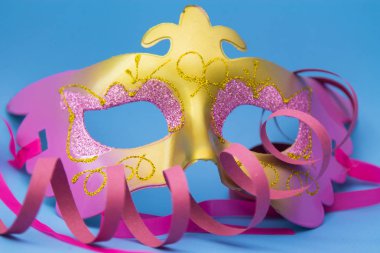 Karnaval maskesi, flamalar ve parlak mavi arka planda konfeti.