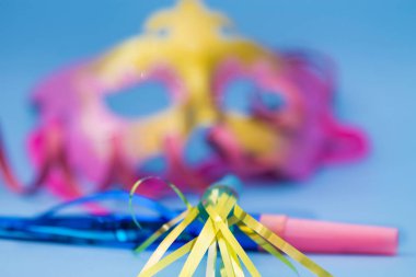 Karnaval maskeleri ve hava üfleyicileri mavi arka planda