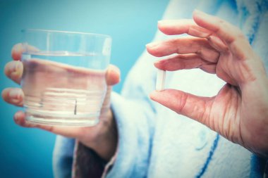 Bir bardak suyla hap alan yaşlı bir kadın, ilaç ve sağlık konsepti