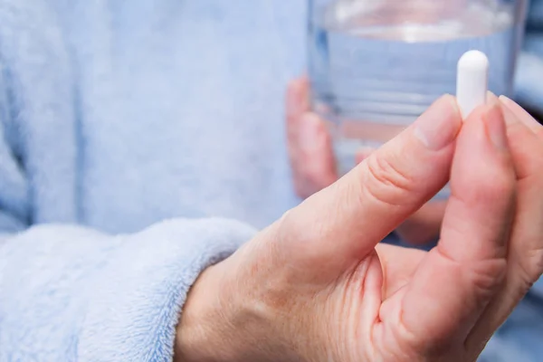 Γυναίκα Χάπια Κάψουλες Στο Χέρι Και Ένα Ποτήρι Νερό — Φωτογραφία Αρχείου