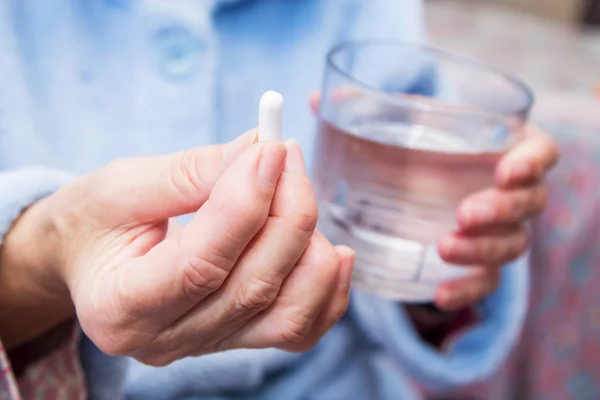 Γυναίκα Χάπια Κάψουλες Στο Χέρι Και Ένα Ποτήρι Νερό — Φωτογραφία Αρχείου