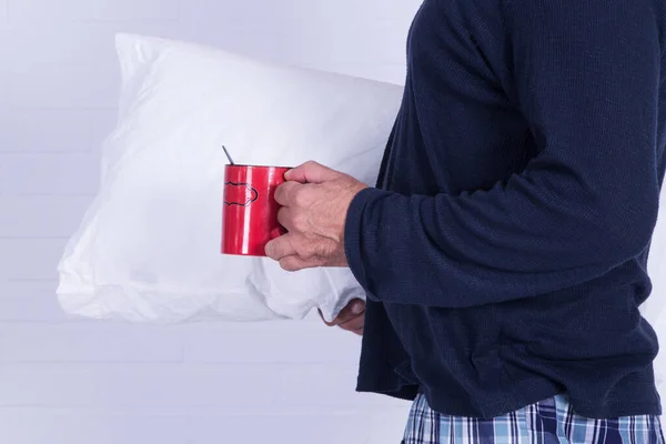 man in pajamas and pillow with his cup of coffee isolated