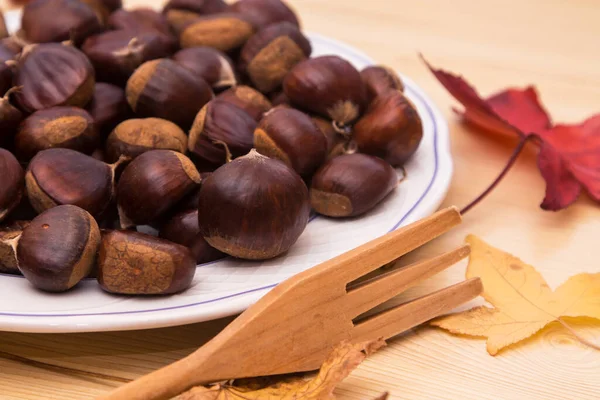 Plaat Van Kastanjes Houten Achtergrond Bladeren — Stockfoto