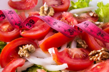 Mezura ile marul, domates ve ceviz salatası. diyet ve sağlık kavramı