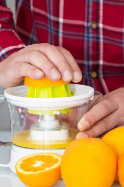 Adam taze narenciye suyu hazırlıyor.