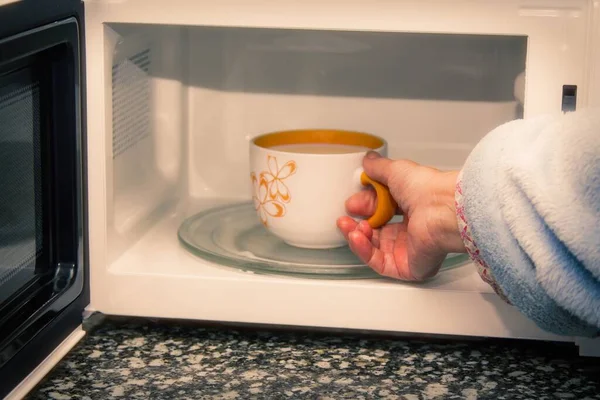 Woman Hand Using Bringing Coffe Cup Microwave Oven Home Reheat — Stock Photo, Image
