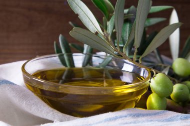 Ekstra saf zeytinyağlı cam kap ve dallı zeytin.