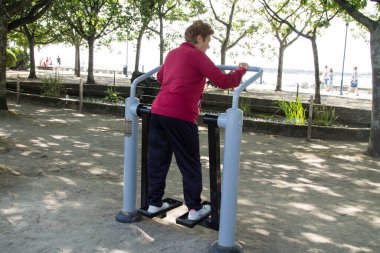 Dışarıda egzersiz ve spor yapan son sınıf öğrencisi mutlu bir kadın.