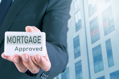 İpoteklerle ilgili bir kartı olan bir iş adamı. mortgage ve iş konsepti