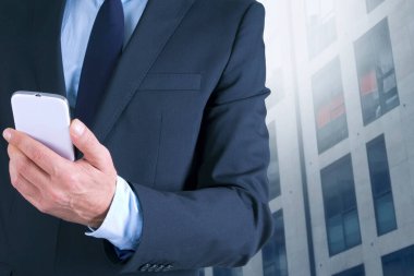 Cep telefonu ve binaları olan iş adamı