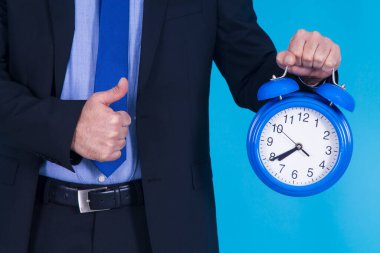 Çalar saati olan bir iş adamı ve parmağıyla 