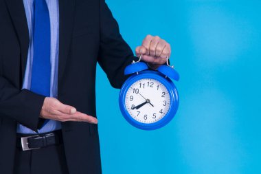 Çalar saati elle gösteren bir işadamı